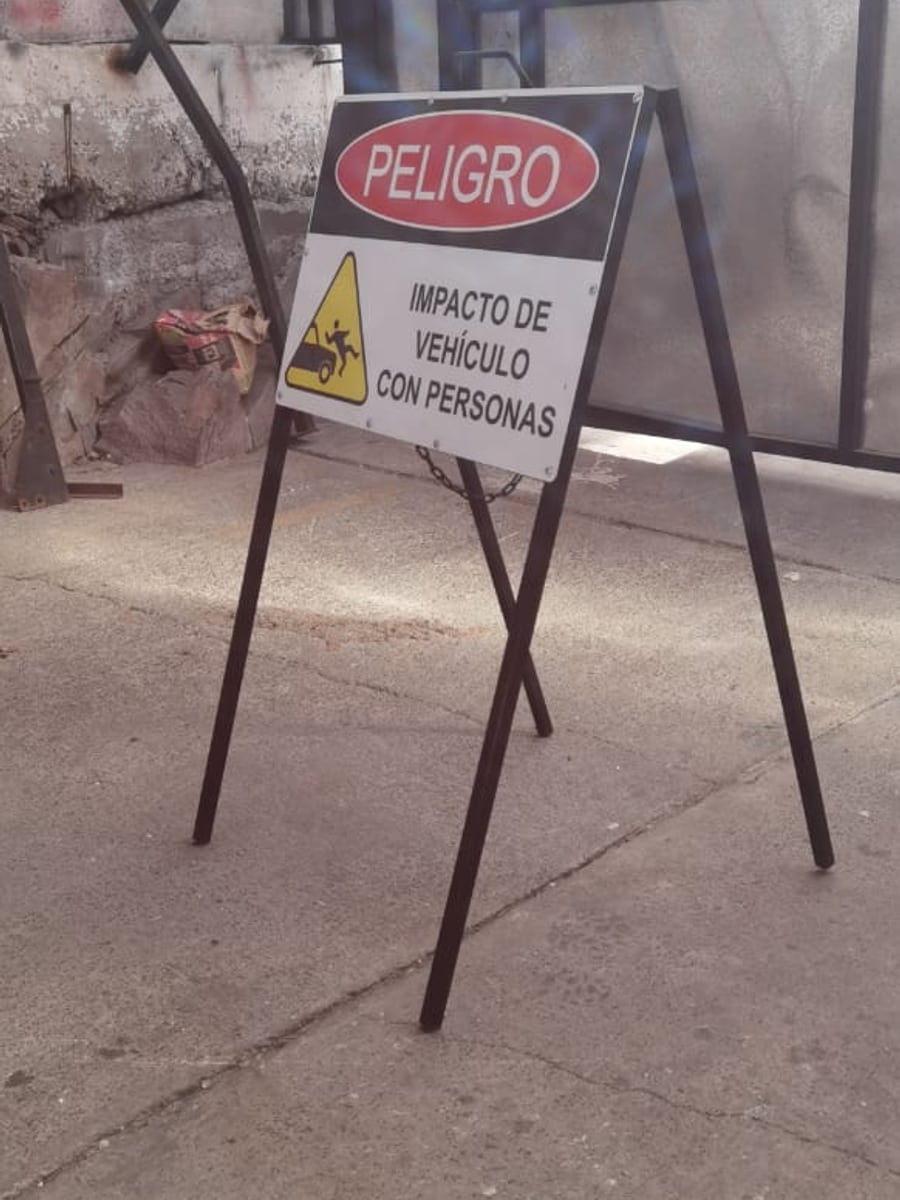 Letrero de peligro en atril metálico